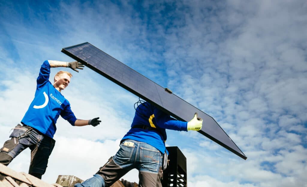 Zonnepaneel leggen op het dak door 2 Samenstromen medewerkers